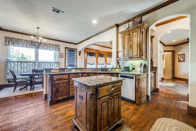 a kitchen with granite countertop a stove and a wooden floors