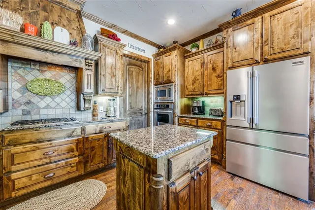 a kitchen with a stove a refrigerator and a stove top oven