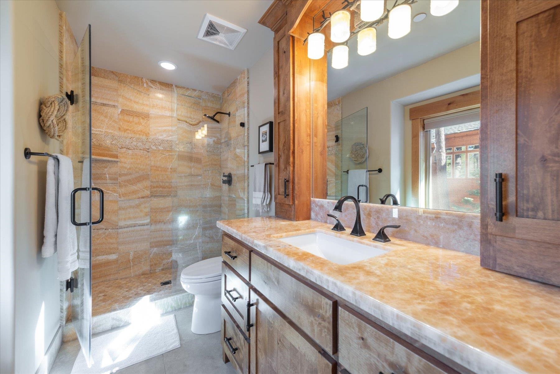 14791 Tyrol Road Truckee, CA 96161 - Photo 13 of 24 a bathroom with a granite countertop sink a toilet and shower
