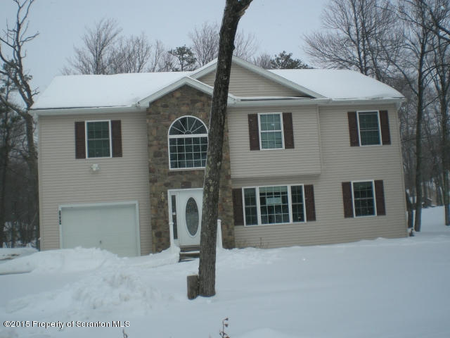 1002 Laurel Road Pocono Summit, PA 18346 - Photo 1 of 13 a front view of a house with a yard and garage