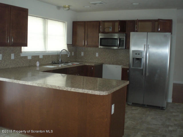 1002 Laurel Road Pocono Summit, PA 18346 - Photo 7 of 13 a kitchen with stainless steel appliances granite countertop a sink a microwave a refrigerator and a granite counter tops