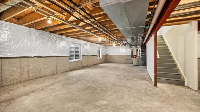 a view of empty room with wooden stairs and windows
