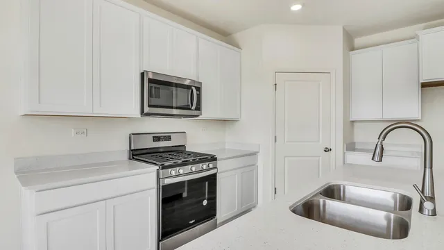a kitchen with granite countertop white cabinets stainless steel appliances and a sink