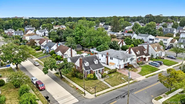 an aerial view of residential houses with outdoor space and trees