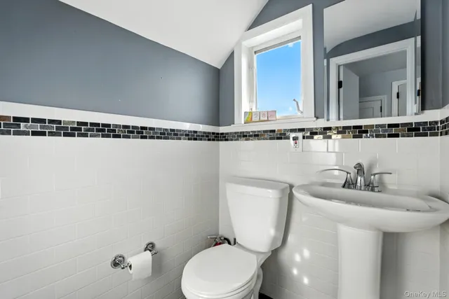 a bathroom with a toilet a sink and mirror