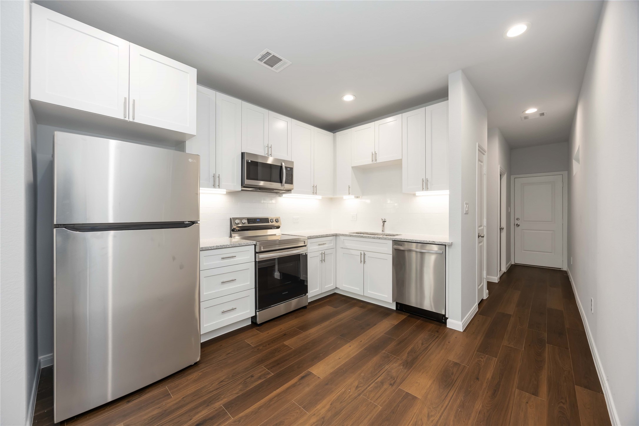 4938 Paradigm Ln Spring Spring, TX 77379 - Photo 8 of 26 a kitchen with a refrigerator a stove top oven a sink and dishwasher with wooden floor