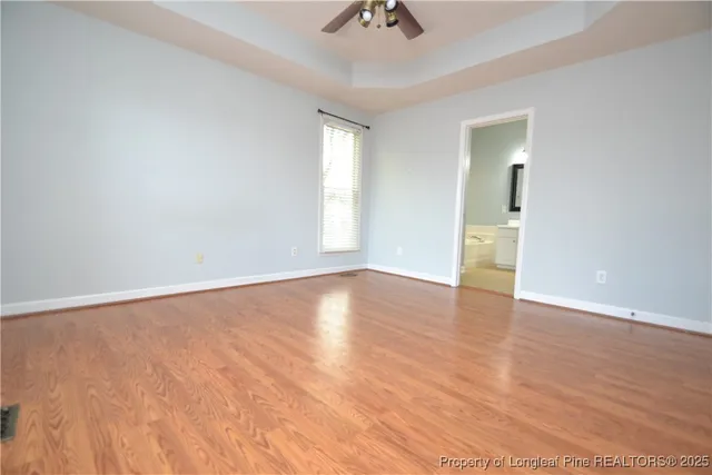 a view of an empty room and window and wooden floor