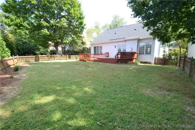 a view of backyard with deck and garden