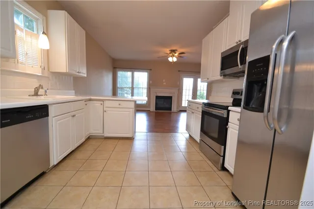 a large kitchen with a stove a sink dishwasher and a refrigerator