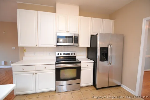 a kitchen with cabinets stainless steel appliances and a counter top space