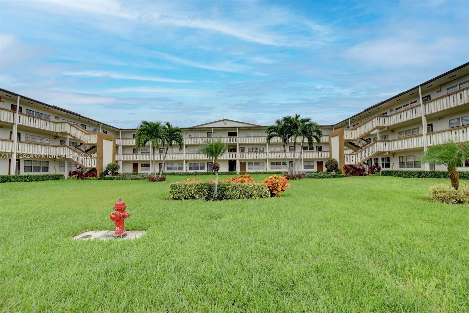 46 Mansfield B Boca Raton, FL 33434 - Photo 63 of 70 a front view of a house with a yard and trees