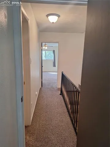 a view of a hallway with wooden floor and stairs