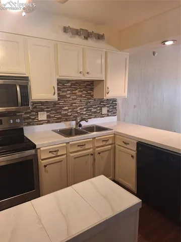 a kitchen with a sink stove and cabinets