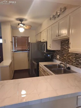a kitchen with a refrigerator sink and cabinets
