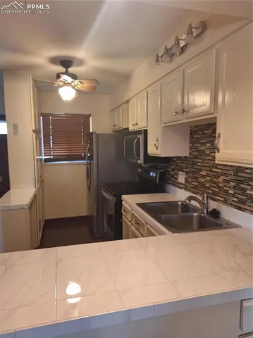 a kitchen with a refrigerator sink and cabinets