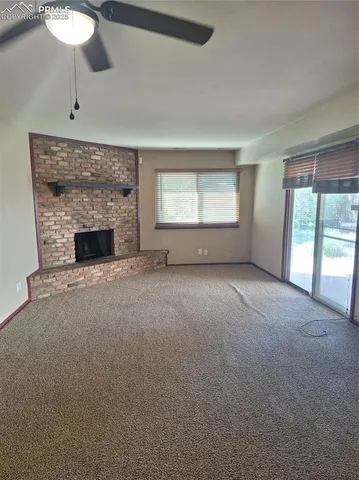 an empty room with windows and fireplace