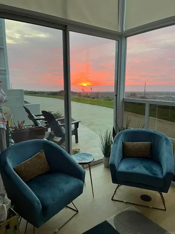 a living room with patio furniture and a floor to ceiling window