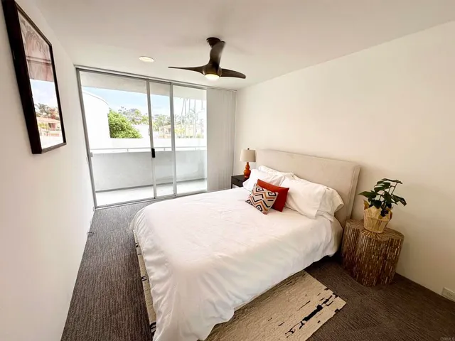 a bedroom with a bed and a large window