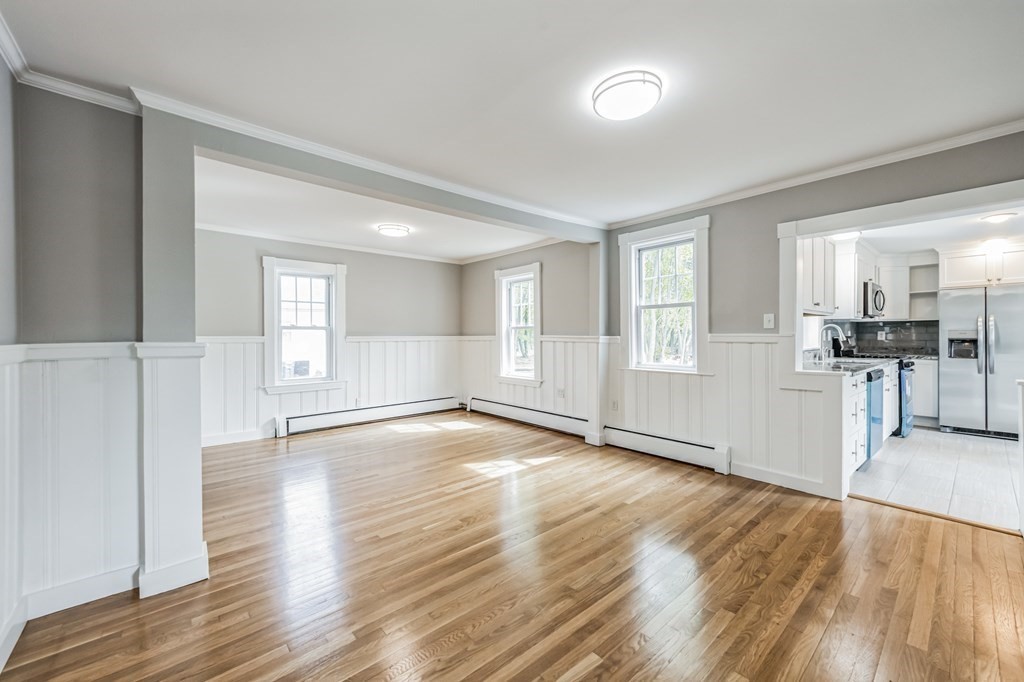54 Concord Road Billerica, MA 01821 - Photo 8 of 30 a view of empty room with wooden floor and kitchen