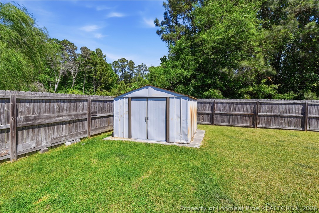 140 Birch Avenue Spring Lake, NC 28390 - Photo 11 of 49 a view of backyard with wooden fence and large trees