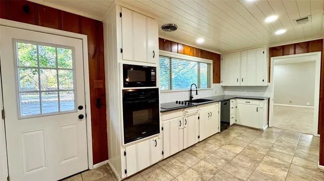 a bathroom with a toilet a double vanity sink and a mirror