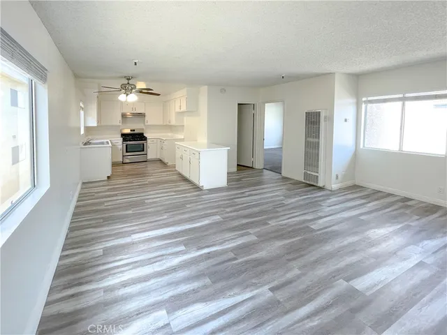 a view of a kitchen with wooden floor and windows