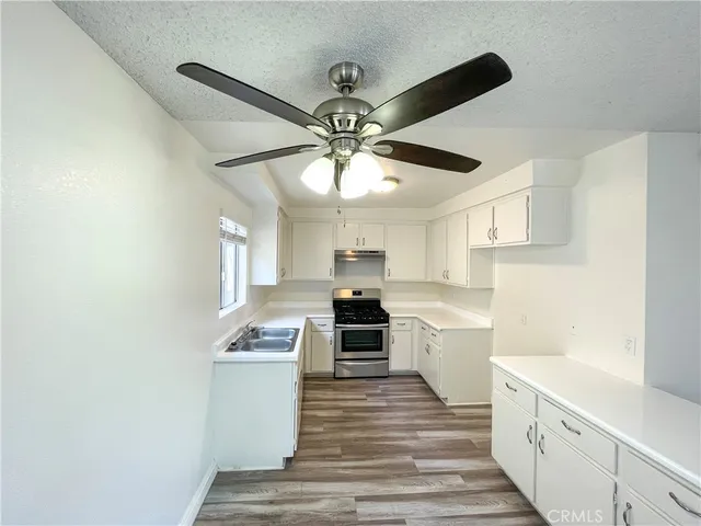 a kitchen with a stove cabinets and window