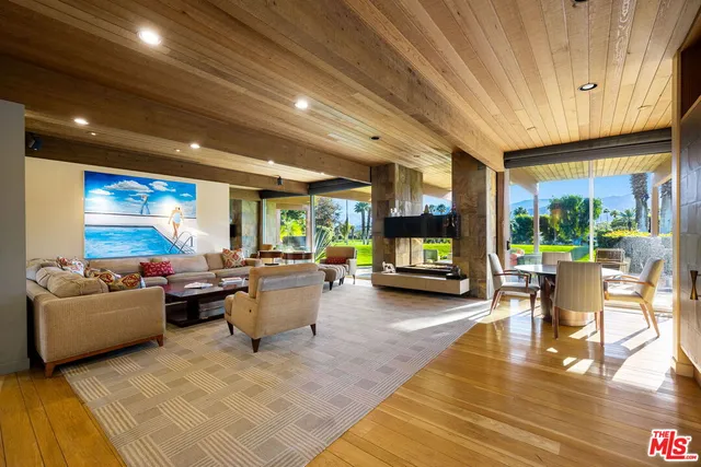 a living room with furniture flat screen tv and a large window