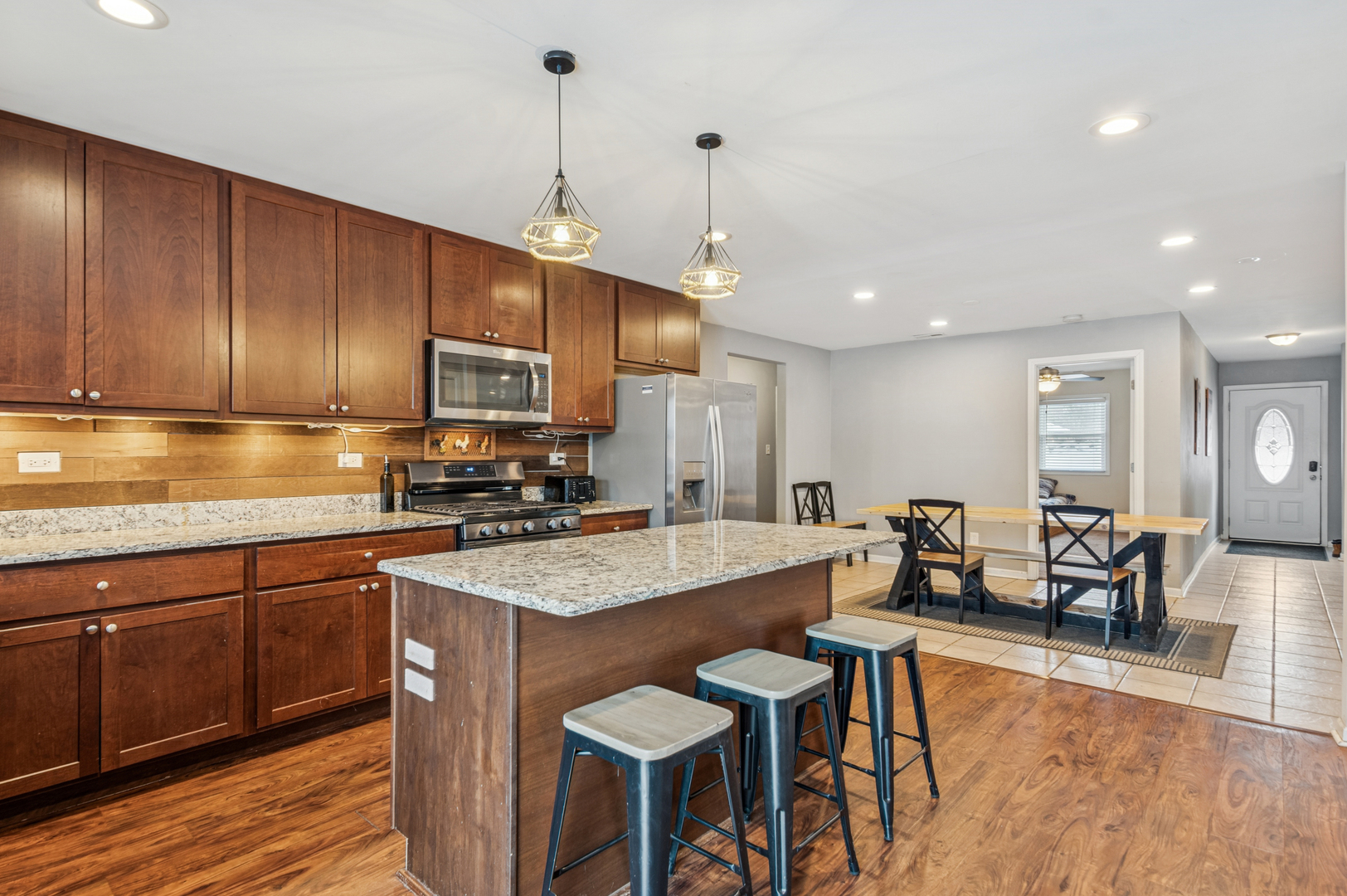 2113 Highwood Road McHenry, IL 60051 - Photo 10 of 18 a kitchen with a dining table chairs stainless steel appliances and cabinets