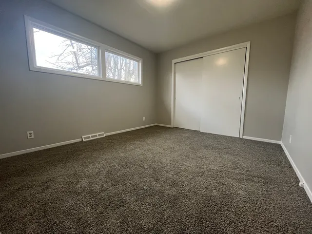 an empty room with windows and closet