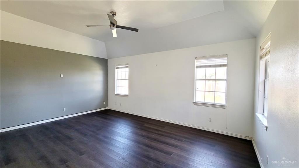 3003 El Jardin Street Mission, TX 78572 - Photo 23 of 25 an empty room with wooden floor chandelier fan and windows