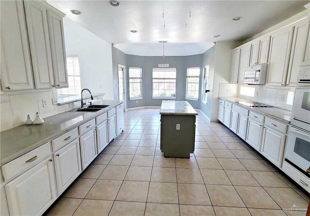 3003 El Jardin Street Mission, TX 78572 - Photo 7 of 25 a large kitchen with stainless steel appliances granite countertop a sink counter space cabinets and a large window