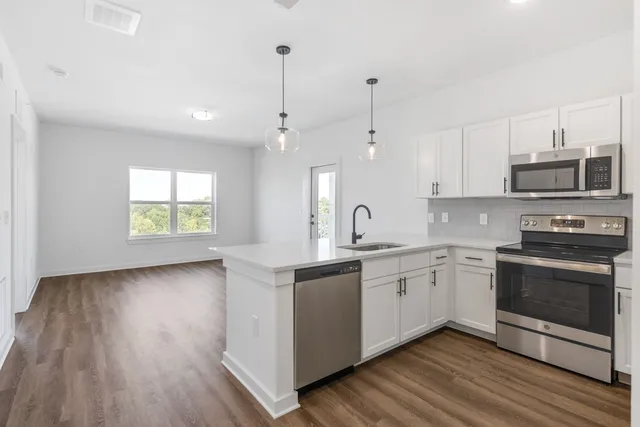 a kitchen with stainless steel appliances granite countertop white cabinets a sink and dishwasher