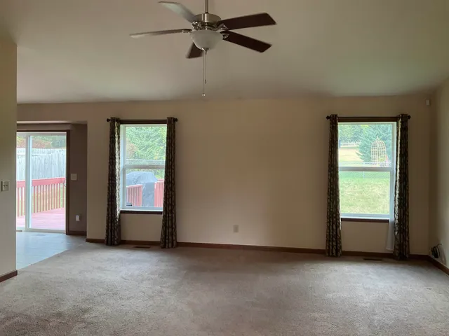 a view of a livingroom with a ceiling fan and window