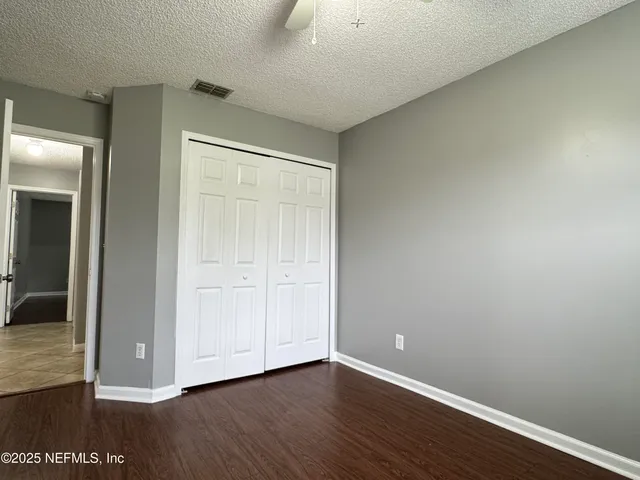 an empty room with wooden floor and closet