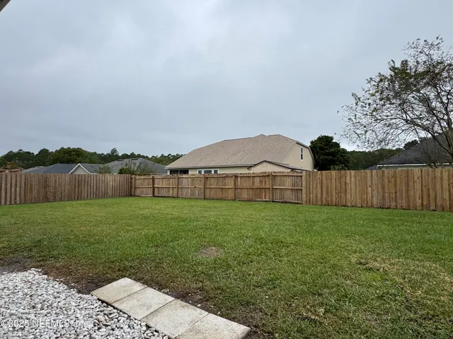 a view of a big yard next to a house and lake view