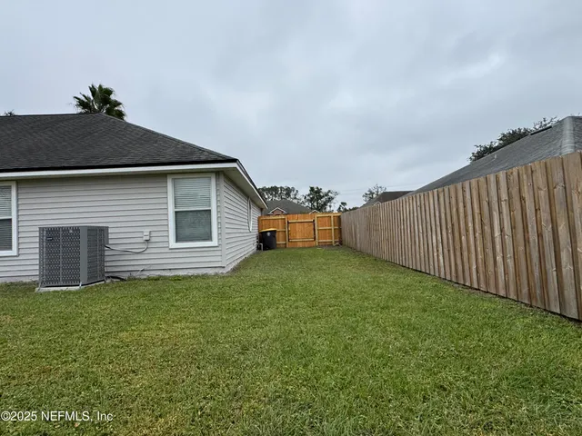 a backyard of a house with lots of green space and plants