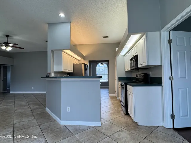 a kitchen with stainless steel appliances granite countertop a refrigerator and a stove