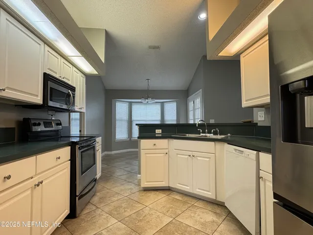 a kitchen with stainless steel appliances granite countertop a sink and a stove