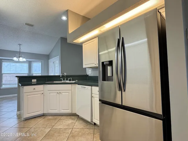 a kitchen with stainless steel appliances granite countertop a refrigerator and a sink