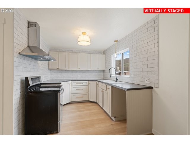 420 Water Street Heppner, OR 97836 - Photo 11 of 48 a kitchen with a sink dishwasher a stove and a refrigerator with wooden floor