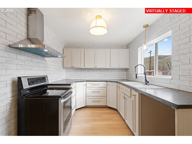 420 Water Street Heppner, OR 97836 - Photo 12 of 48 a kitchen with granite countertop a sink a stove and cabinets