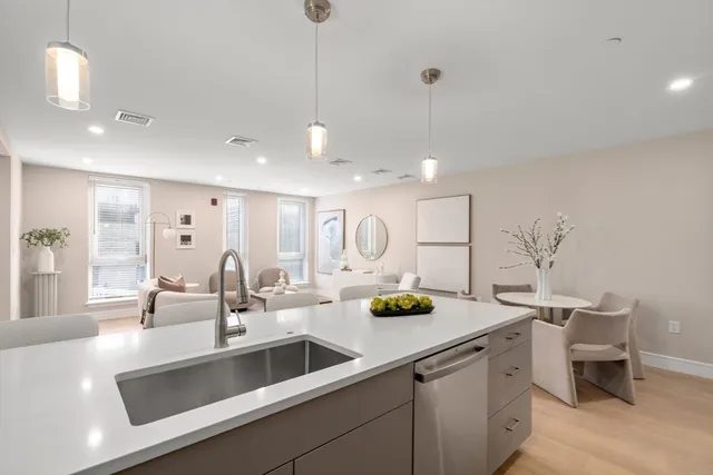 a kitchen with a sink a counter and chairs