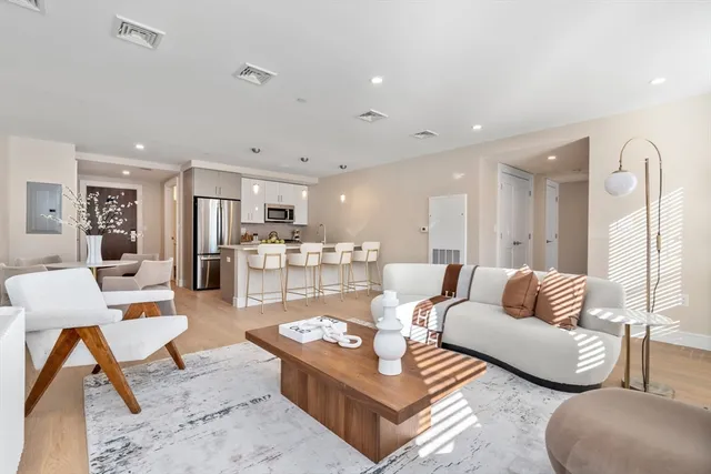 a living room with furniture and view of kitchen