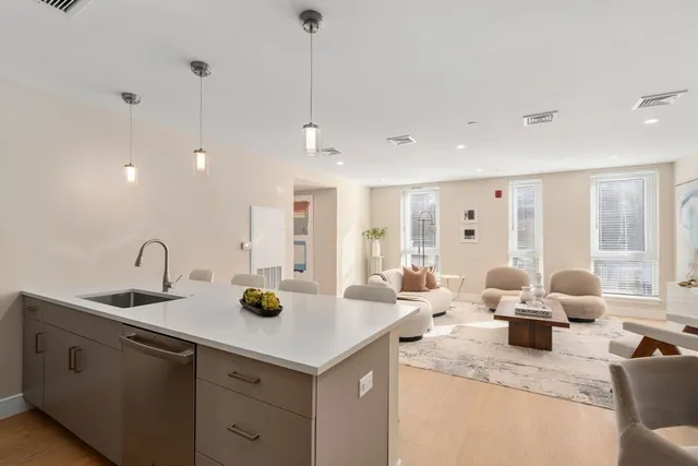 a kitchen with a sink a counter and chairs
