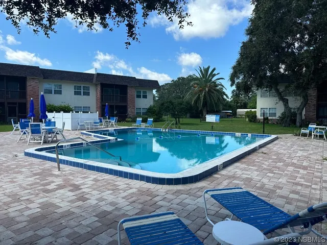 a view of a house with swimming pool and sitting area