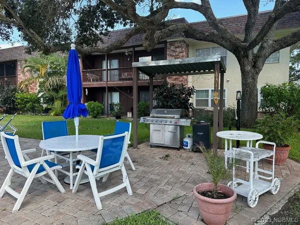 a view of a chairs and table in backyard of the house