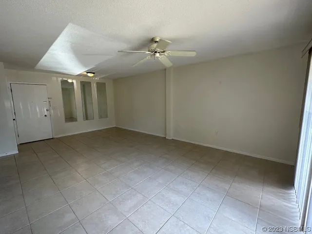 an empty room with windows and fan