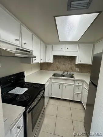 a kitchen with a stove a sink and cabinets