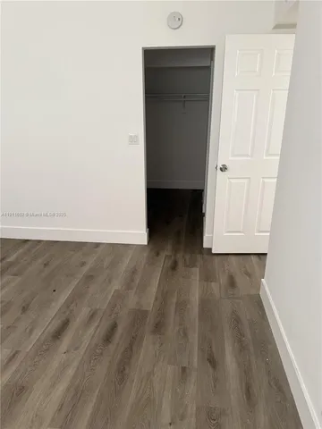 an empty room with wooden floor and closet